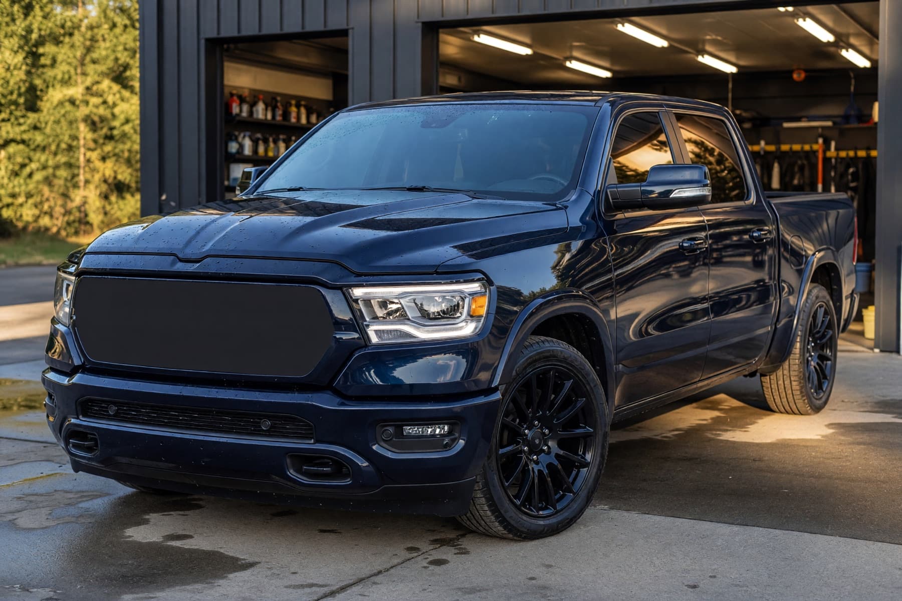 Finished dark blue pickup truck outside an auto detailing bay